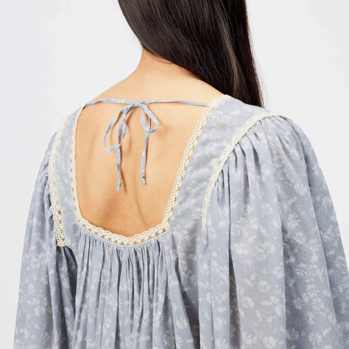 DRYKORN ISMARA Babydoll Tunika-Bluse mit hellblauem Blumenprint, Spitzenborte am Ausschnitt, langen Ärmeln und lockerer A-Linien-Passform.