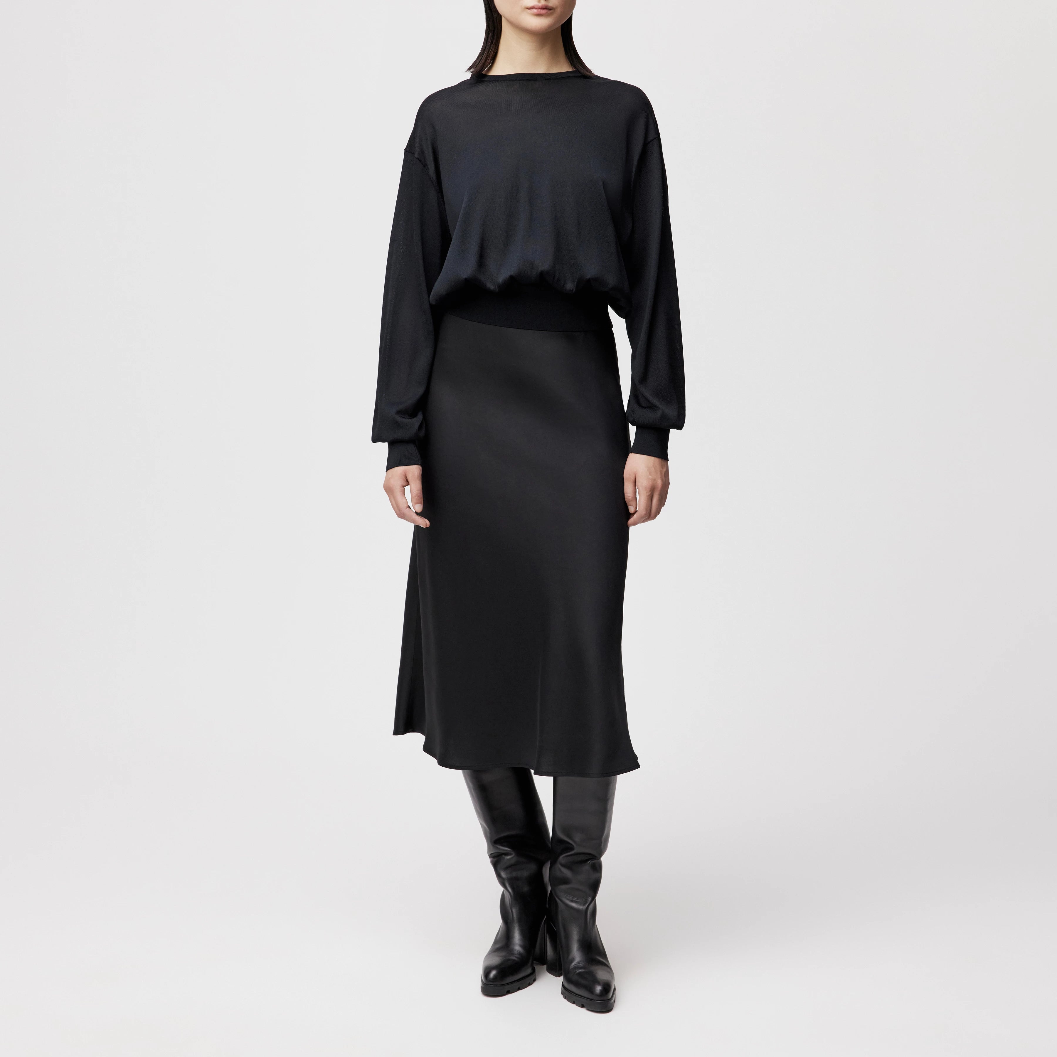 Model trägt den oversized DRYKORN Strickpullover TALOMINA mit Ballonärmeln und Rundhalsausschnitt aus feinem Acetat in lässiger Passform.