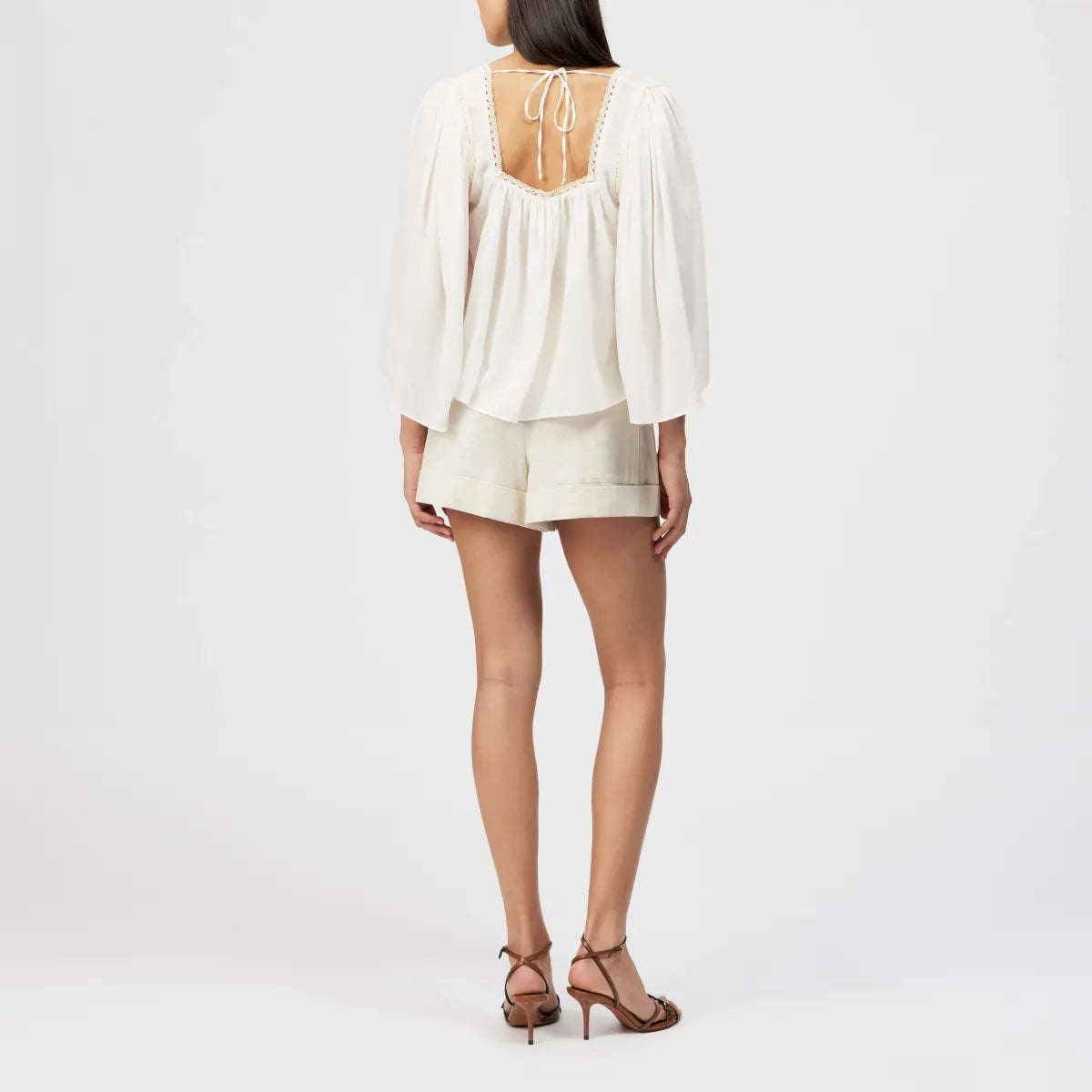 Drykorn Tunika-Bluse ISMARA in Cremeweiß mit weitem Ärmel, Spitzenborte am Ausschnitt und fließender A-Linien-Silhouette. Feminine Sommerbluse aus Baumwoll-Viskose-Mix mit leichter Crêpe-Struktur.