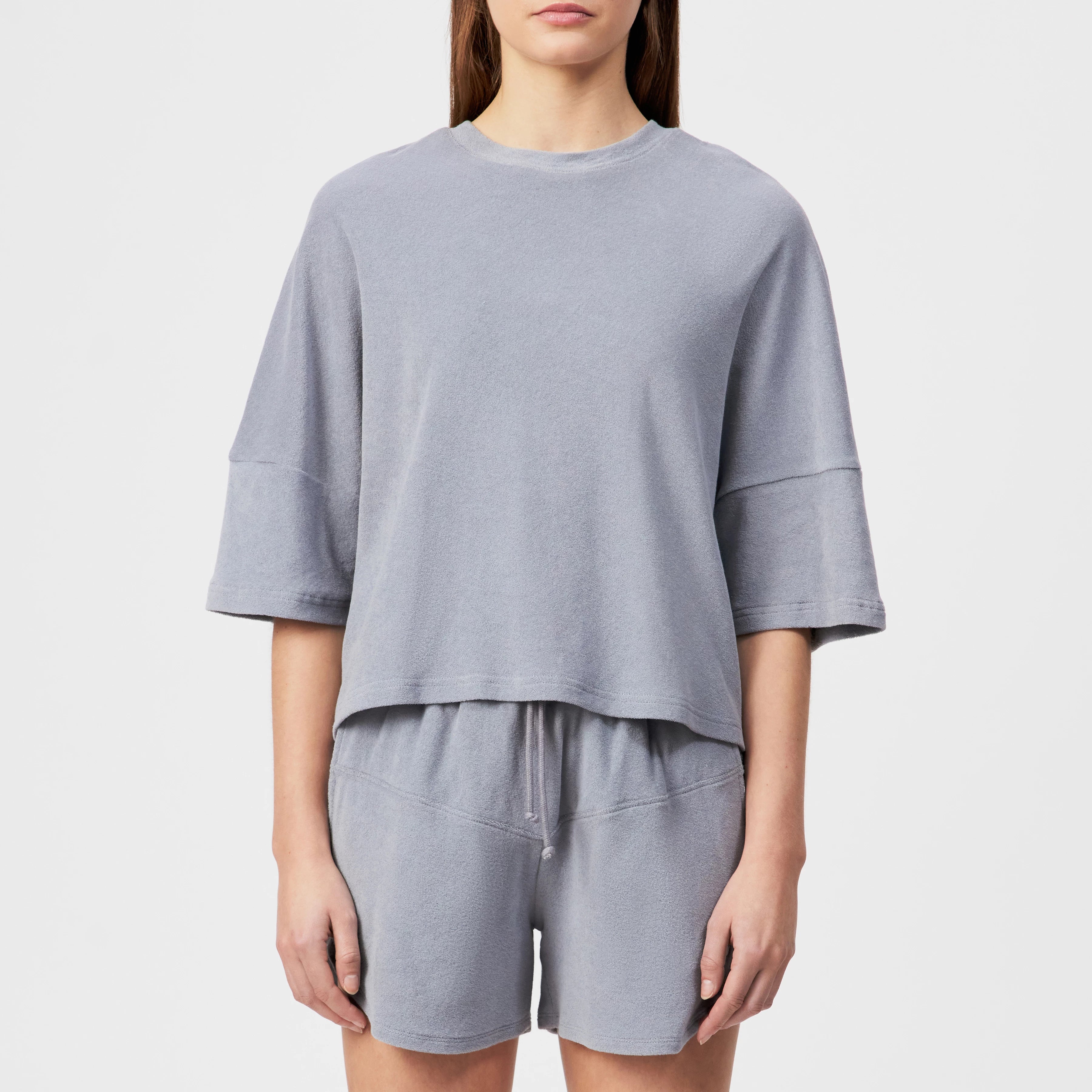DRYKORN KUSIA T-Shirt aus weißem Baumwoll-Frottee mit Relaxed Fit, Rundhalsausschnitt, kurzen Ärmeln und dezenter Logo-Stickerei auf dem Rücken.