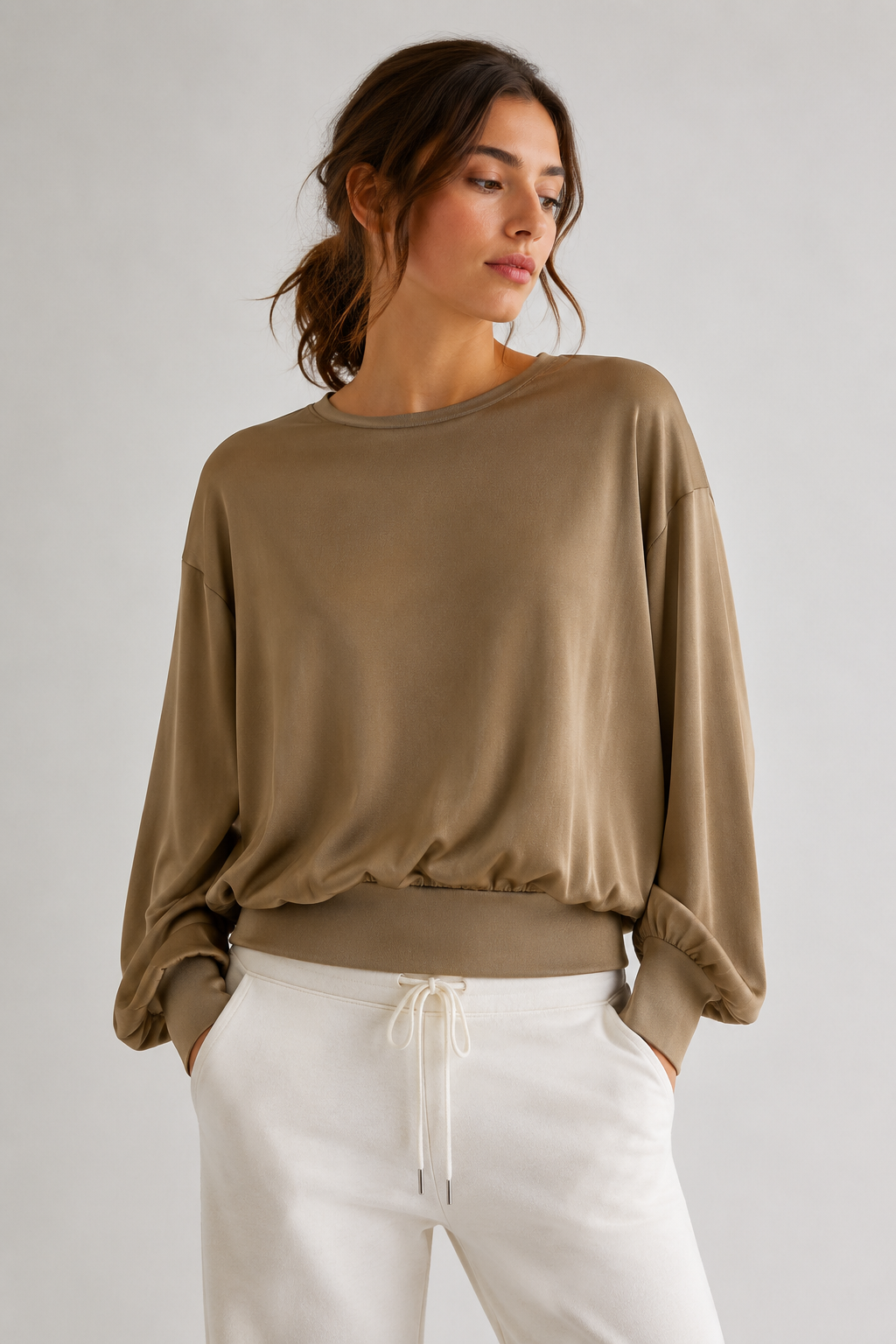 Model trägt den grünen DRYKORN TALOMINA Oversized Strickpullover mit Ballonärmeln und Rundhalsausschnitt aus fließender Acetat-Qualität.