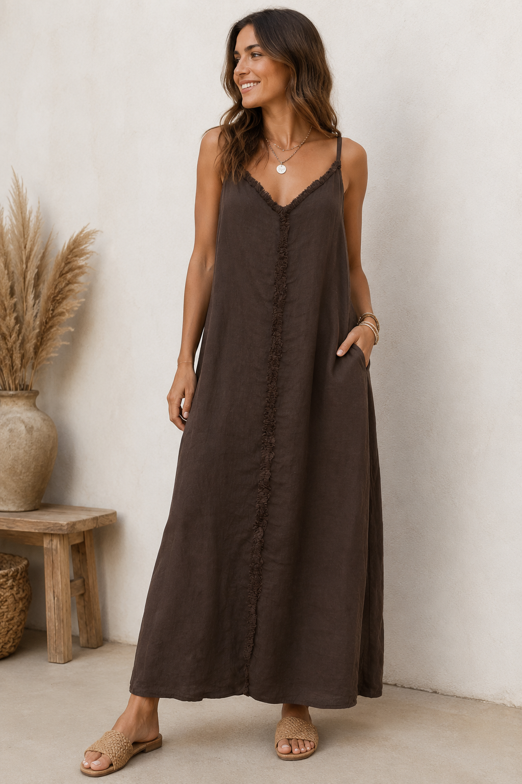 Braunes Maxikleid mit Spaghettiträgern und dekorativer Rüschennaht vorne von Marta du Chateau auf weißem Hintergrund.