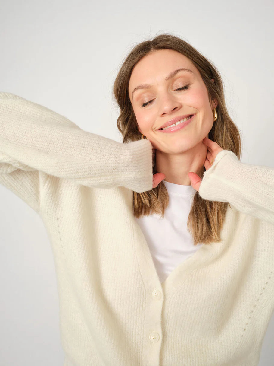 Model trägt den cremefarbenen Mos Mosh THORA Cardigan aus weichem Alpaka-Wollmix mit V-Ausschnitt und Knopfleiste.