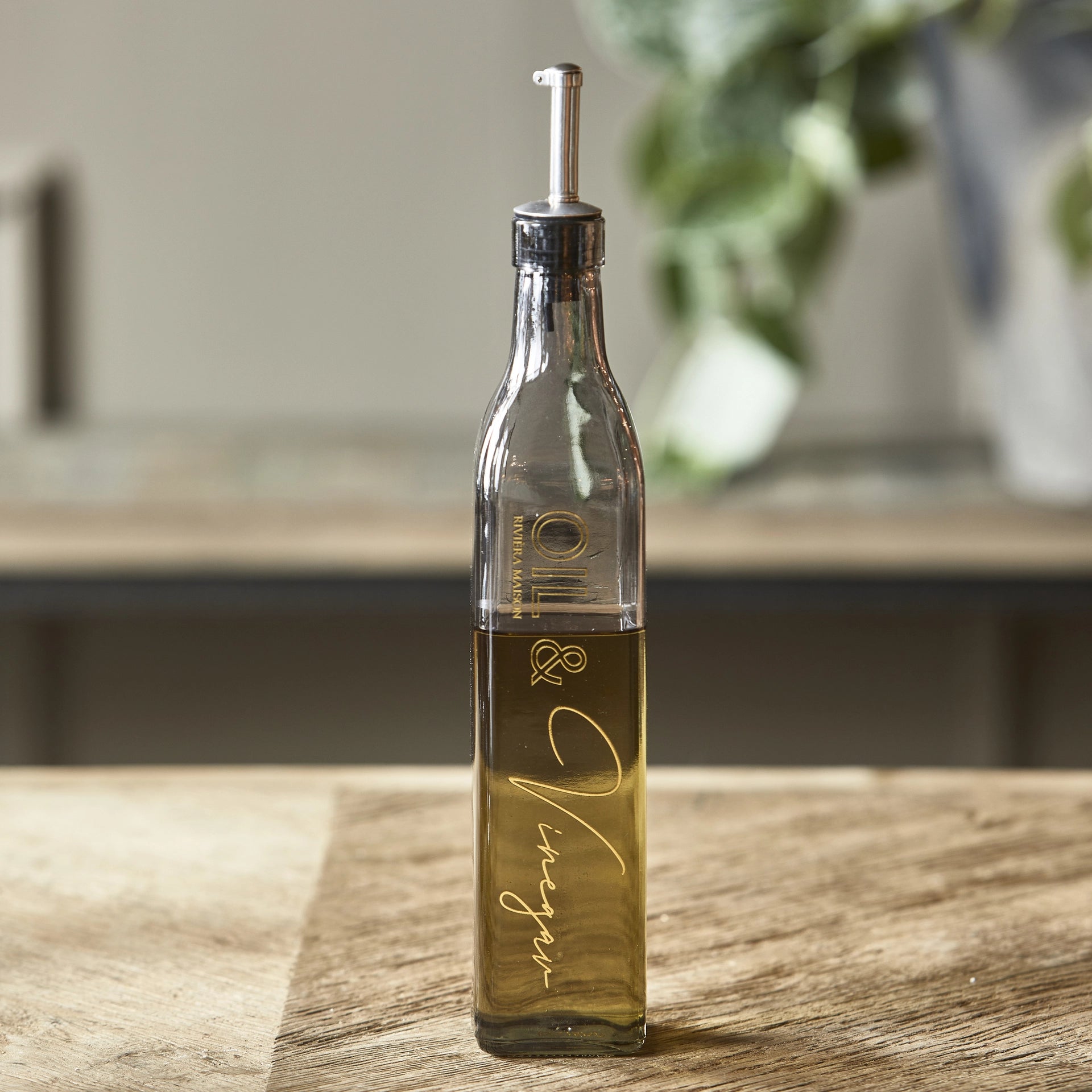 Riviera Maison Oil & Vinegar Bottle aus getöntem Glas mit Ausgießer und goldfarbenem Schriftzug.