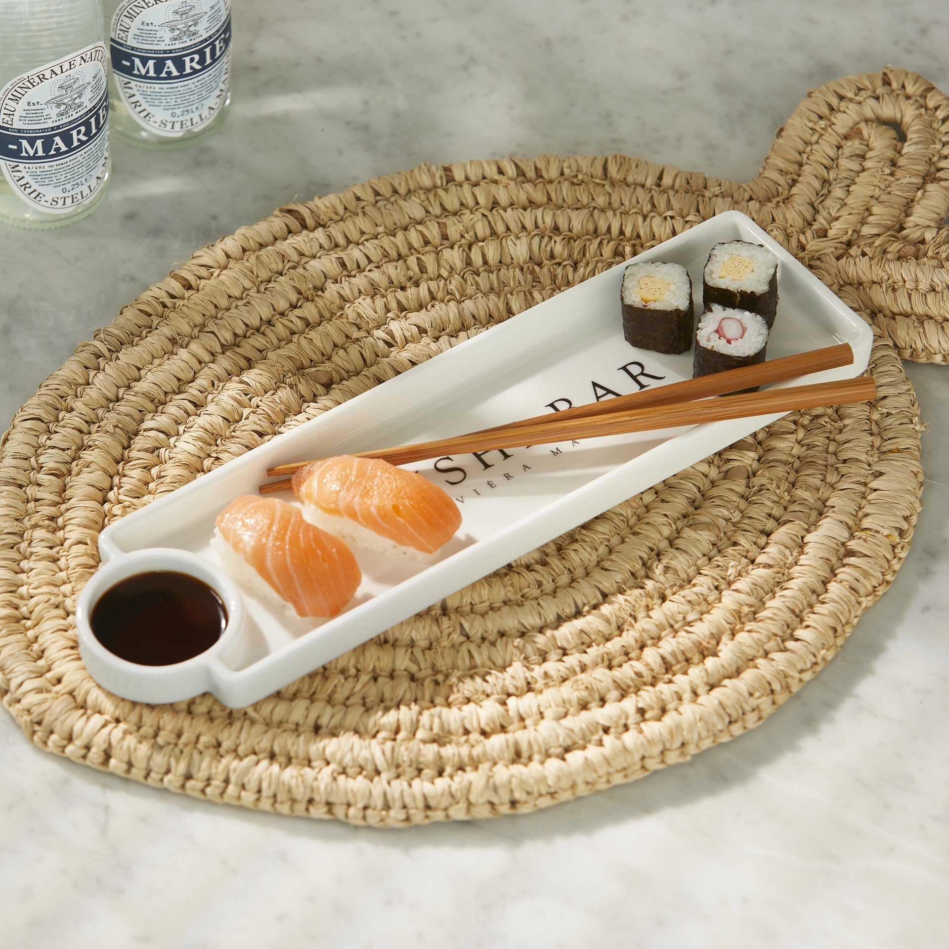 Riviera Maison Sushi Bar Plate aus weißer Keramik mit integrierter Sojasaucenschale und Essstäbchen auf einem rustikalen Holztisch.
