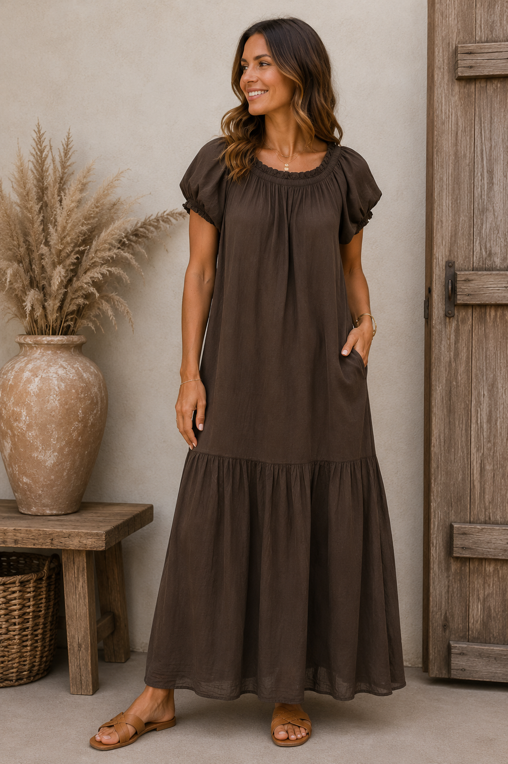 Braunes Maxikleid mit Puffärmeln, elastischem Rundhalsausschnitt und Volantsaum von Marta du Chateau auf weißem Hintergrund.