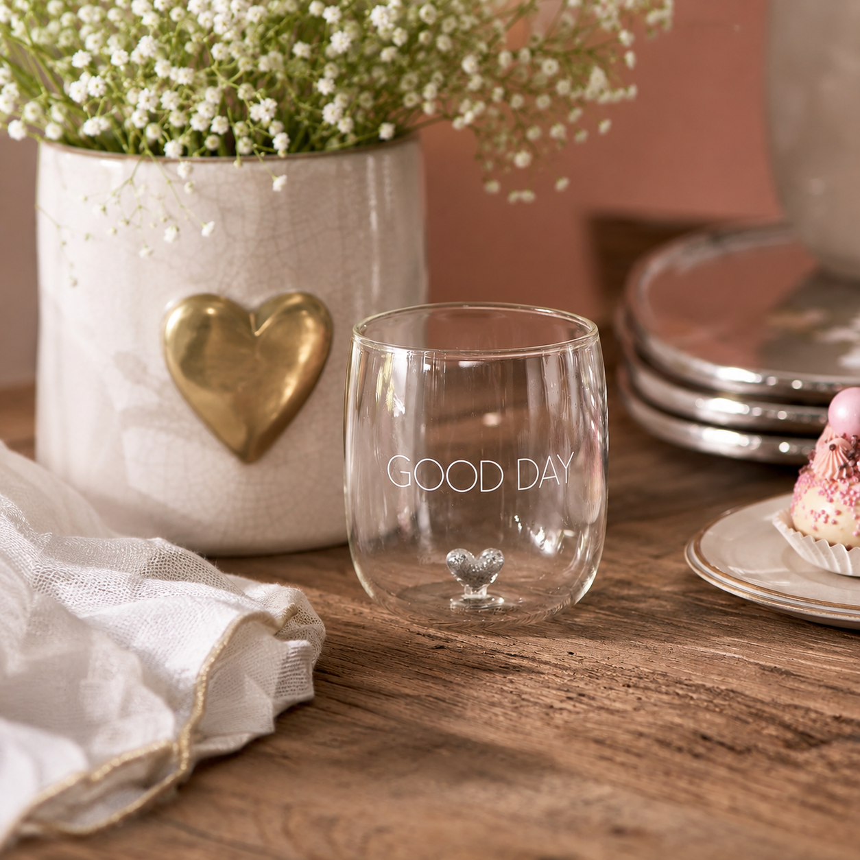 Wasserglas von Riviera Maison mit der Aufschrift GOOD DAY und einem kleinen silbernem Herzen im Glas