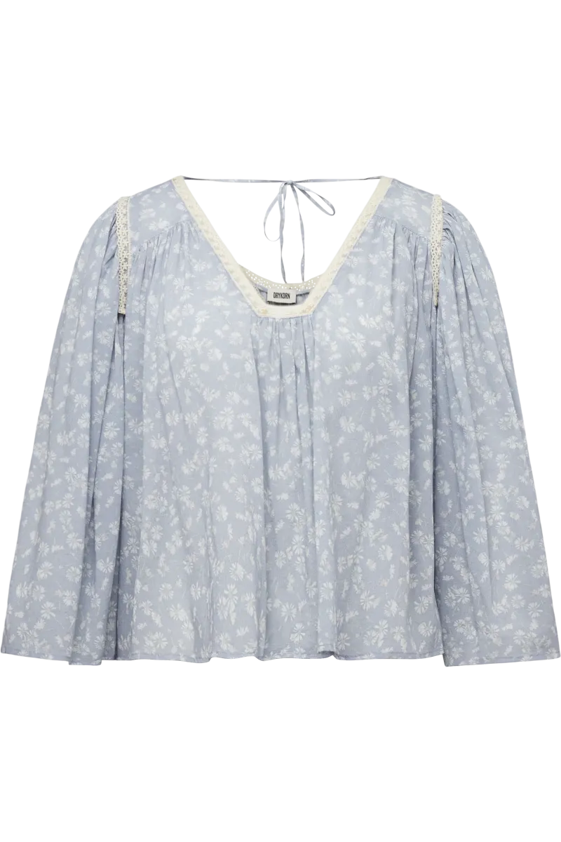 DRYKORN ISMARA Babydoll Tunika-Bluse mit hellblauem Blumenprint, Spitzenborte am Ausschnitt, langen Ärmeln und lockerer A-Linien-Passform.