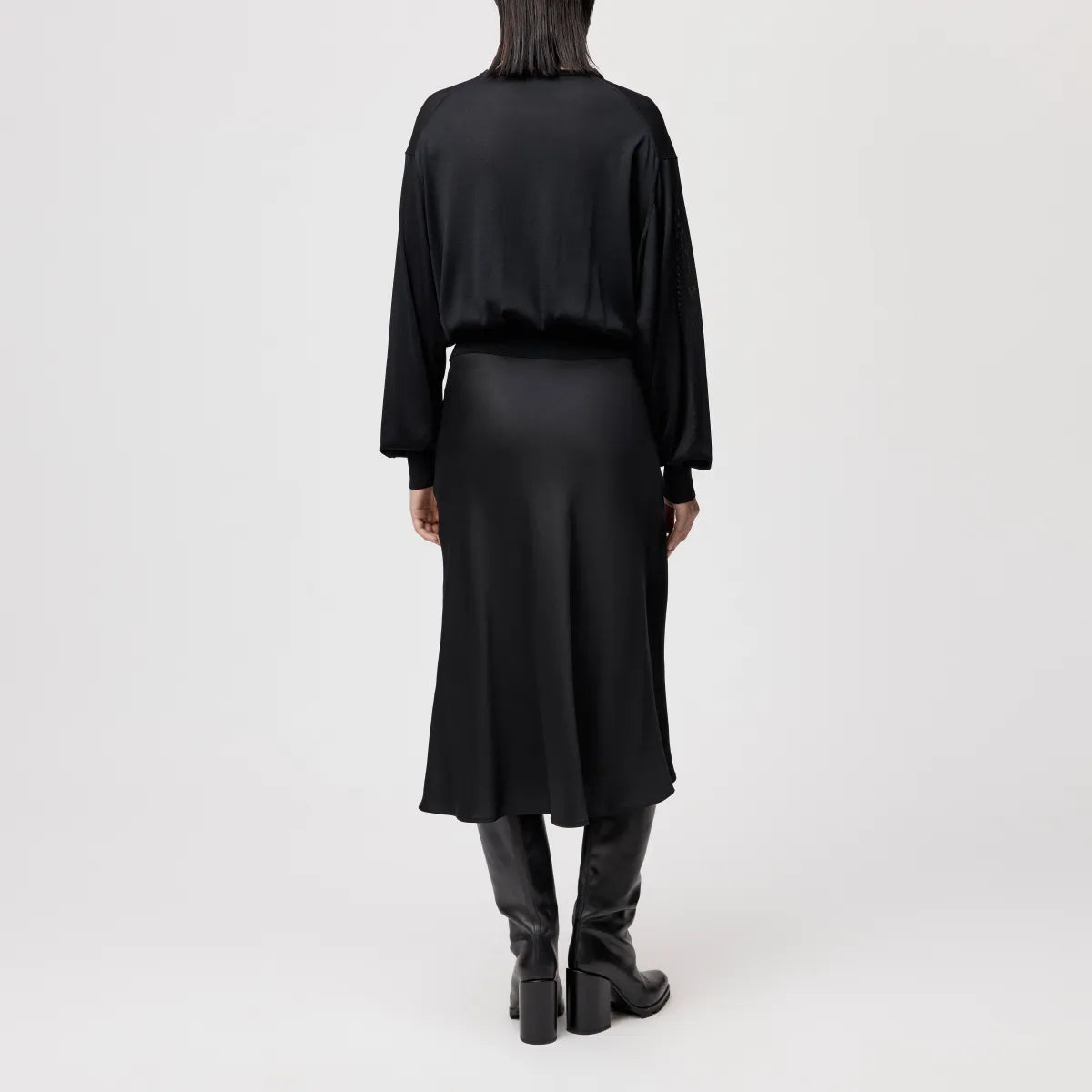 Model trägt den oversized DRYKORN Strickpullover TALOMINA mit Ballonärmeln und Rundhalsausschnitt aus feinem Acetat in lässiger Passform.