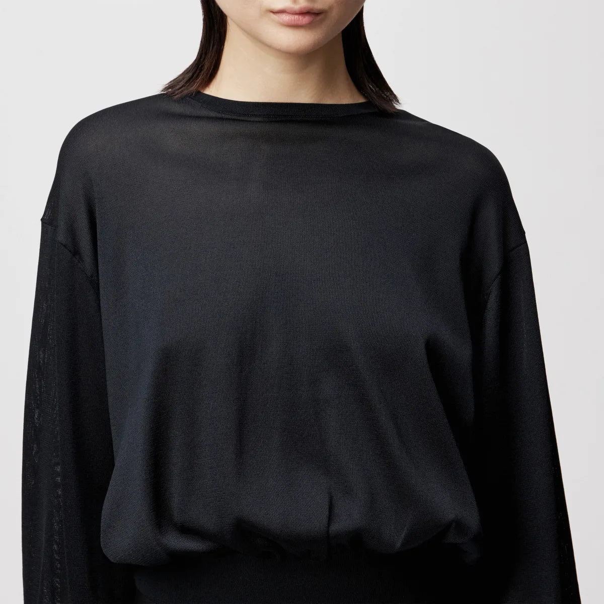 Model trägt den oversized DRYKORN Strickpullover TALOMINA mit Ballonärmeln und Rundhalsausschnitt aus feinem Acetat in lässiger Passform.