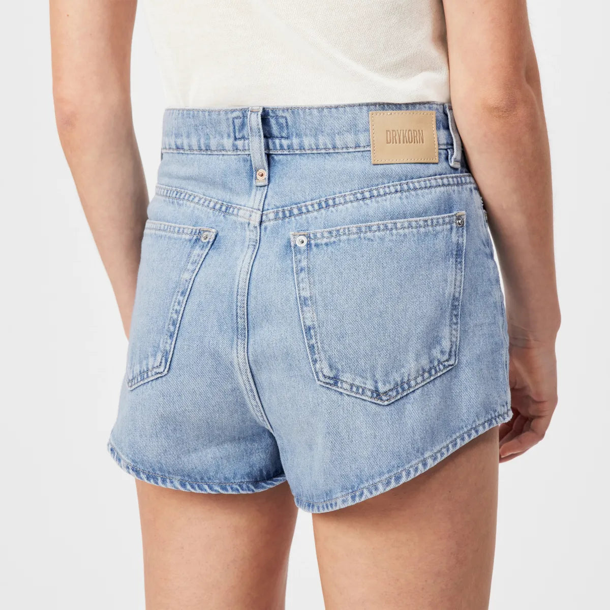 Drykorn Denim Shorts SNUCK aus hell gewaschenem Baumwoll-Denim mit High-Waist-Bund, Relaxed Fit und klassischem 5-Pocket-Design. Lässige Damen-Jeansshorts mit dezentem Used-Look.