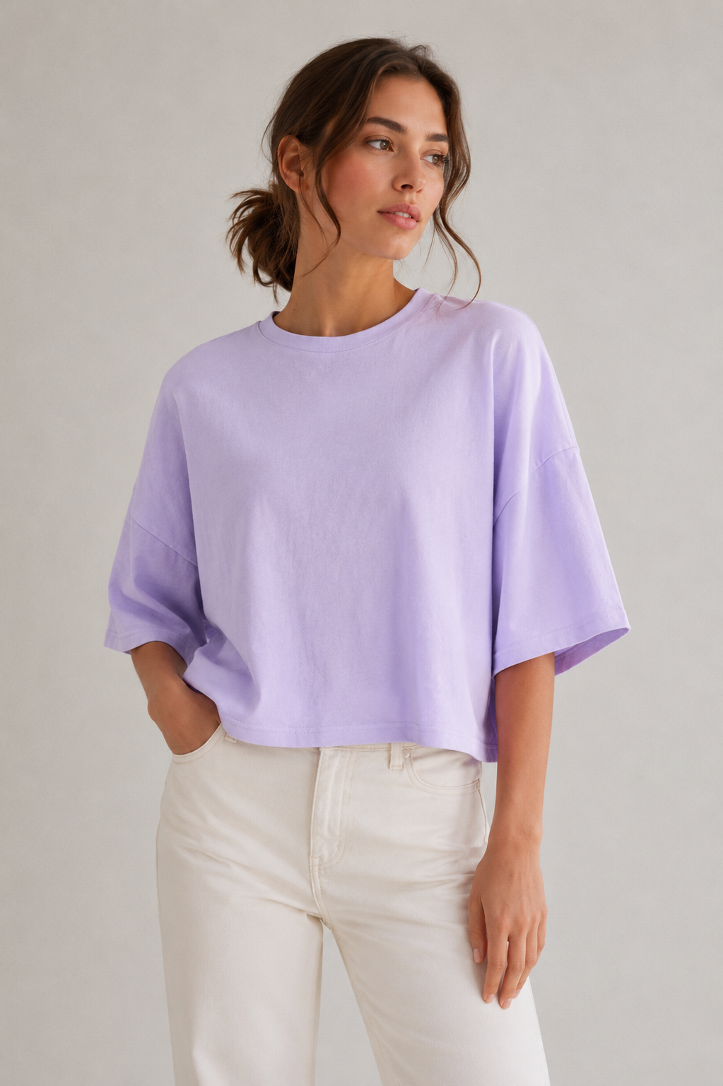 Model trägt das fliederfarbene DRYKORN MARVA Baumwoll-T-Shirt mit lockerem Boxy Fit, weiten Ärmeln und verkürzter Länge.
