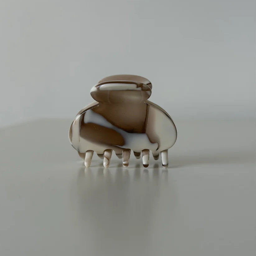 Kleine Haarklammer von JONA THE LABEL in marmorierter Braun-Beige-Optik mit glänzender Oberfläche.