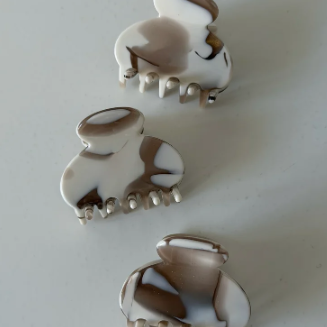 Kleine Haarklammer von JONA THE LABEL in marmorierter Braun-Beige-Optik mit glänzender Oberfläche.