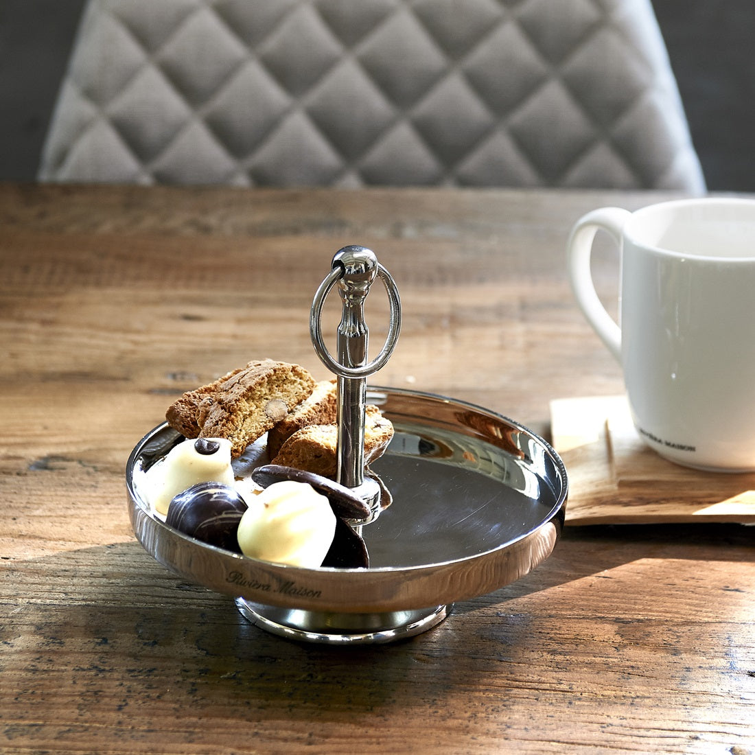 Riviera Maison Camden Cake Stand aus Aluminium in Silber mit Standfuß und dekorativem Tragegriff.