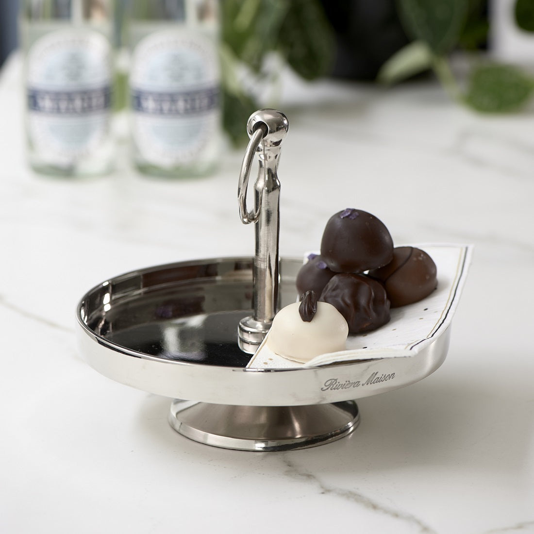 Riviera Maison Camden Cake Stand aus Aluminium in Silber mit Standfuß und dekorativem Tragegriff.