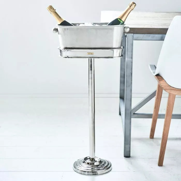 Riviera Maison Champagne Cooler on Stand aus Metall mit zwei Champagnerflaschen in einer mit Eis gefüllten Kühlschale.
